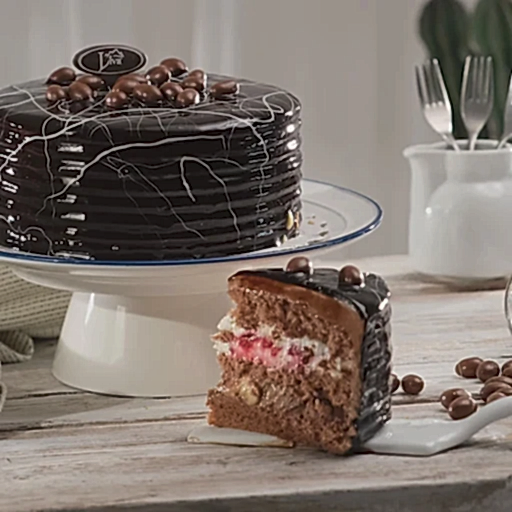 bir dilim ve bütün olarak yan yana duran drajeli çikolatalı yaş pasta